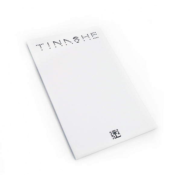 Image of a white notebook against a white background. The top of the notebook says 