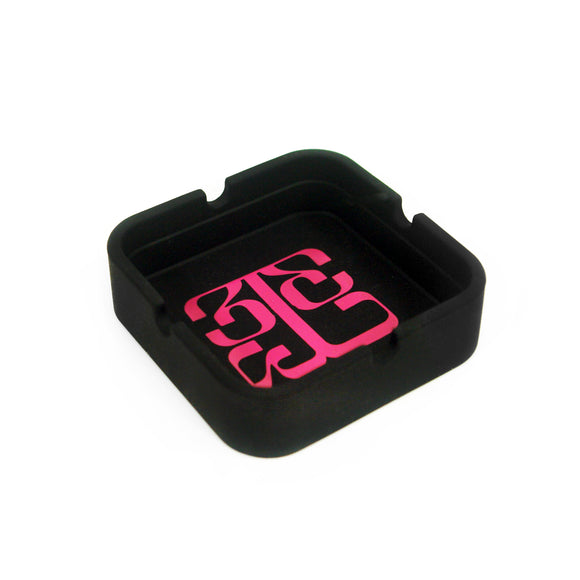 Image of a black ashtray against a white background. The inside center of the ashtray features the tinashe 333 logo in a pink color. The logo is a 3 facing the right way, mirrored by a 3 facing the opposite way, connected to a large 3 that is sideways and across the bottom of the other two 3's, forming a square shaped logo.